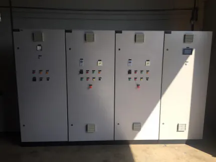 Painel elétrico de quatro colunas, em chapa cinza clara, com botoeiras, sinaleiros e uma IHM na porta da direita.